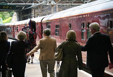 A piper leads the way to the Royal Scotsman train at Edinburgh